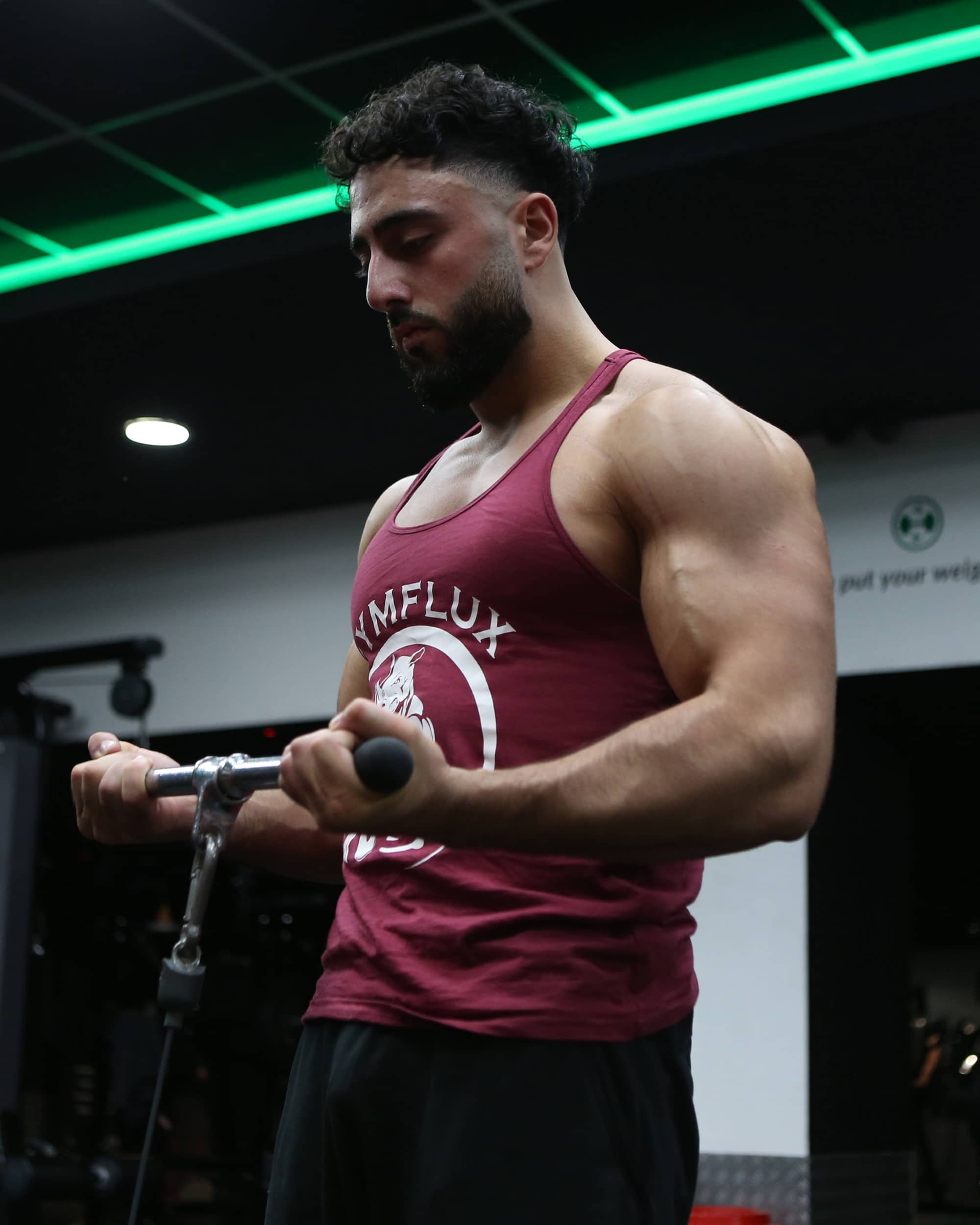 Coach Yusif in the gym doing bicep curls